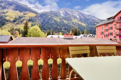 a balcony with a table and chairs and mountains at Résidence La Ginabelle - maeva Home - Appartement 3 pièces 6 personnes - Prestige MAE-7151 in Chamonix-Mont-Blanc