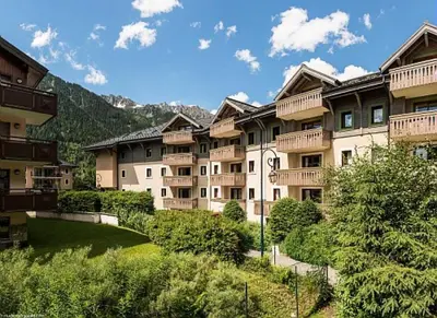 a group of apartment buildings with a grassy yard at Résidence La Ginabelle - maeva Home - Appartement 3 pièces 6 personnes - Prestige MAE-7151 in Chamonix-Mont-Blanc