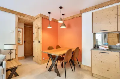 a kitchen and dining room with a wooden table and chairs at Résidence La Ginabelle - maeva Home - Appartement 3 pièces 6 personnes - Prestige MAE-7151 in Chamonix-Mont-Blanc