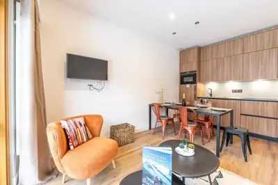 a living room with a table and a dining room at Sweet Home Brevent - Happy Rentals in Chamonix-Mont-Blanc