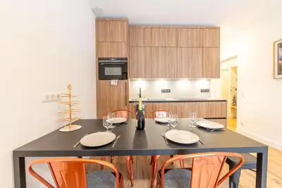 a kitchen with a black table and orange chairs at Sweet Home Brevent - Happy Rentals in Chamonix-Mont-Blanc