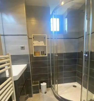 a bathroom with a glass shower and a sink at Appartement, au cœur de Sallanches in Sallanches