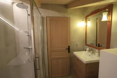 a bathroom with a shower and a sink and a door at Chalet du Bonheur in Saint-Gervais-les-Bains