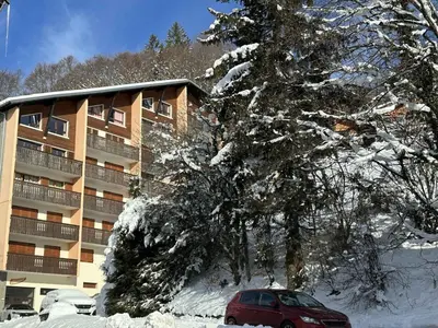 a red car parked in front of a snow covered building at Duplex de 100m² pour 9 personnes au centre proche remontées mécaniques - FR-1-572-290 in Arâches-la-Frasse