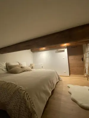 a bedroom with a large bed and a wooden floor at CHALET CAREVA in Les Houches