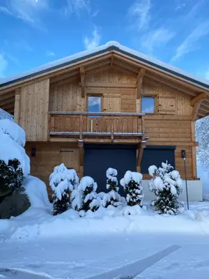 a log cabin in the snow with a garage at Chalet Charline in Combloux