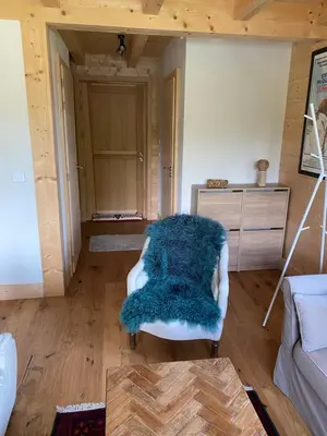 a living room with a blue blanket on a chair at Chalet Charline in Combloux