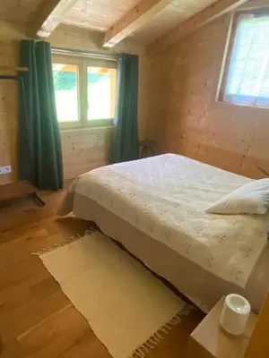 a bedroom with a bed in a wooden house at Chalet Charline in Combloux