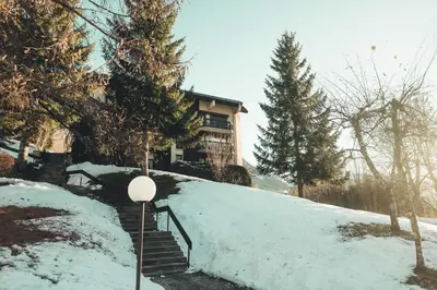 a house on a snow covered hill with stairs at Appartement Keraos - Perfect for a family holiday in Megeve in Megève