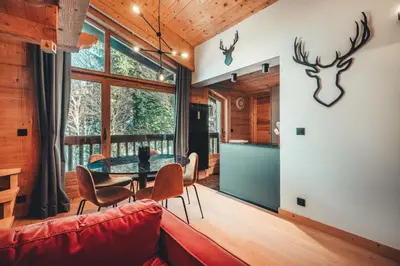 a living room with a red couch and a table at Appartement Keraos - Perfect for a family holiday in Megeve in Megève