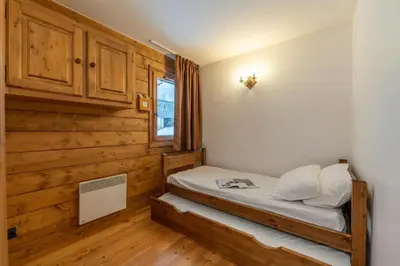 a bedroom with a bed with wooden walls and a window at Appt Bec D1 - Happy Rentals in Chamonix-Mont-Blanc