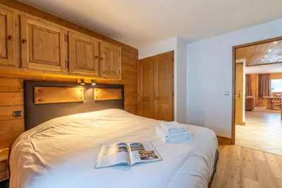 a bedroom with a bed with two books on it at Appt Bec D1 - Happy Rentals in Chamonix-Mont-Blanc