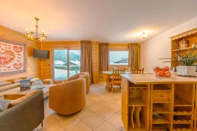 a living room with a table and a dining room at Appt Bec D1 - Happy Rentals in Chamonix-Mont-Blanc