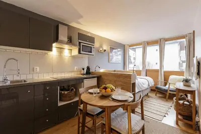 a kitchen with a table with a bowl of fruit on it at Le Cham' 106 - Happy Rentals in Chamonix-Mont-Blanc