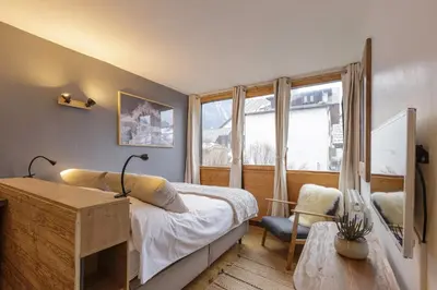 a bedroom with a bed and a desk and a window at Le Cham' 106 - Happy Rentals in Chamonix-Mont-Blanc