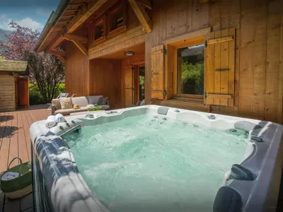 a jacuzzi tub in front of a house at Chalet Evonyx - OVO Network in Samoëns