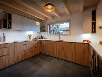 a kitchen with wooden cabinets and a window at Chalet Evonyx - OVO Network in Samoëns