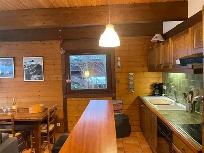a kitchen with a wooden counter top and a table at Apartment Clos du Chantey Moury by Interhome in Chamonix-Mont-Blanc