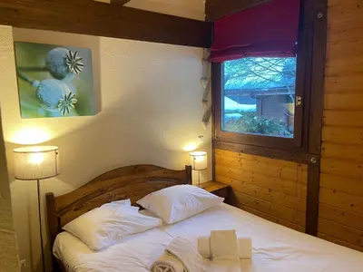 a bedroom with a bed with two lamps and a window at Apartment Clos du Chantey Moury by Interhome in Chamonix-Mont-Blanc