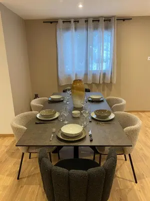 a dining table and chairs with plates and glasses on it at Appartement PISTE ROUGE in Les Houches