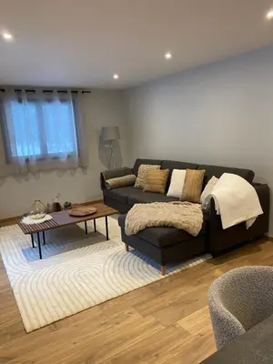 a living room with a black couch and a table at Appartement PISTE ROUGE in Les Houches