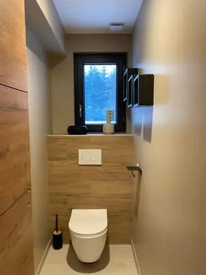 a bathroom with a toilet and a window at Appartement PISTE ROUGE in Les Houches