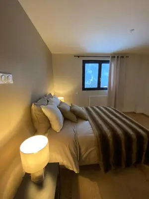 a bedroom with a bed with a lamp and a window at Appartement PISTE ROUGE in Les Houches