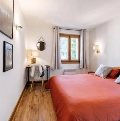 a bedroom with a large red bed and a window at Loriaz 12 - Appartement avec vue et piscine à deux pas du telecabine in Vallorcine