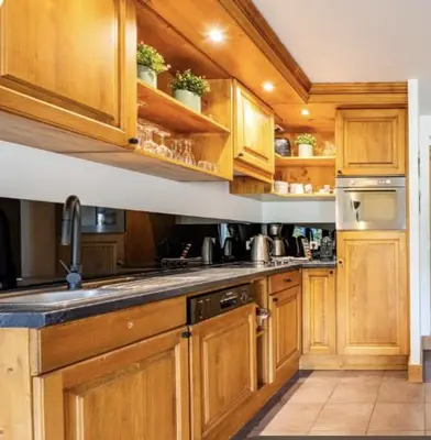 a kitchen with wooden cabinets and a sink at Loriaz 12 - Appartement avec vue et piscine à deux pas du telecabine in Vallorcine