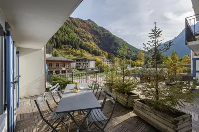 a patio with a table and chairs on a balcony at Loriaz 12 - Appartement avec vue et piscine à deux pas du telecabine in Vallorcine