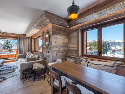 a living room with wooden walls and a table and chairs at Appartement moderne avec accès sauna et hammam - FR-1-569-186 in Megève