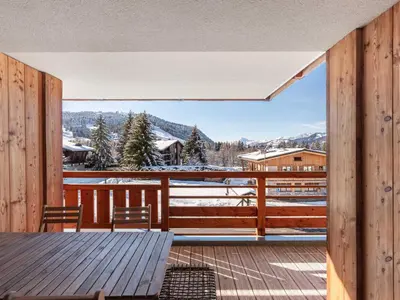 a view from the deck of a house with a table and chairs at Appartement moderne avec accès sauna et hammam - FR-1-569-186 in Megève