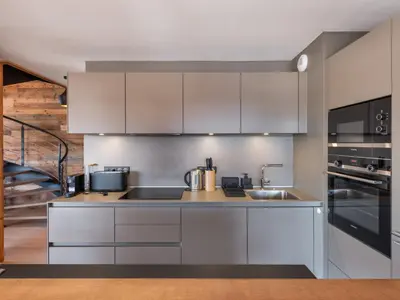 a kitchen with white cabinets and stainless steel appliances at Appartement moderne avec accès sauna et hammam - FR-1-569-186 in Megève