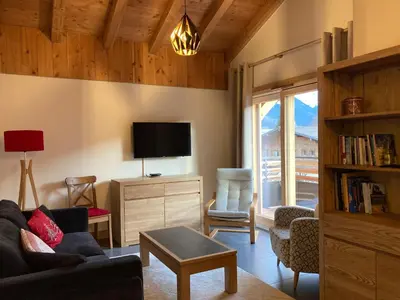 a living room with a couch and a tv at Appartement Rêve de Montagne in Samoëns