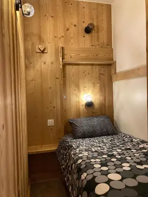 a bedroom with a bed and a wooden wall at Appartement Rêve de Montagne in Samoëns