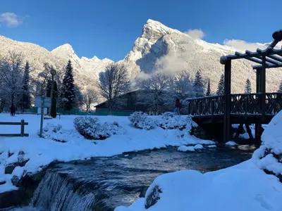 a bridge over a river with snow covered mountains at Appartement Rêve de Montagne in Samoëns
