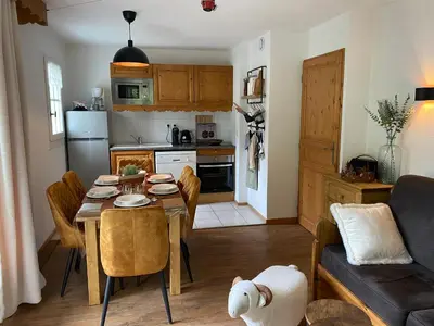 a kitchen and living room with a table and a couch at Côté DÔMES in Saint-Gervais-les-Bains