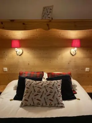 a bedroom with a bed with two lamps and two pillows at Côté DÔMES in Saint-Gervais-les-Bains