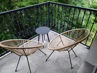 two chairs and a table on a balcony at Côté DÔMES in Saint-Gervais-les-Bains