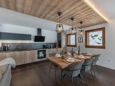 a dining room with a wooden table and chairs at Appartement spacieux à Megève, 3 ch, près des pistes, parking privé - FR-1-569-139 in Megève