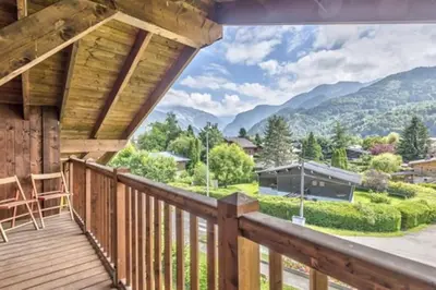 a wooden deck with a view of mountains at Le Chardon Argenté T4 Duplex 4 etoiles - 7 couchages - Parking&Piscine in Samoëns