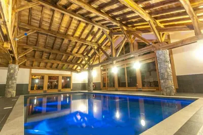 a swimming pool in a building with a wooden ceiling at Le Chardon Argenté T4 Duplex 4 etoiles - 7 couchages - Parking&Piscine in Samoëns