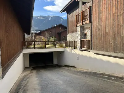 an empty parking lot with a bridge between two buildings at Le Chardon Argenté T4 Duplex 4 etoiles - 7 couchages - Parking&Piscine in Samoëns