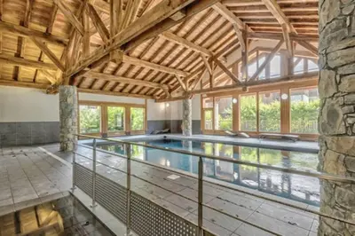 an indoor pool in a house with a wooden ceiling at Le Chardon Argenté T4 Duplex 4 etoiles - 7 couchages - Parking&Piscine in Samoëns