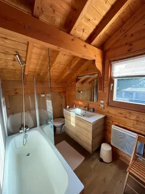 a bathroom with a tub and a sink and a toilet at Chalet de charme aux Carroz d'Arrâches-Flaines in Les Carroz d'Araches