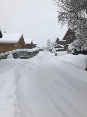 a snow covered road with snow covered houses at Chalet de charme aux Carroz d'Arrâches-Flaines in Les Carroz d'Araches