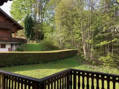 a view of a garden from a wooden balcony at Chalet de charme aux Carroz d'Arrâches-Flaines in Les Carroz d'Araches