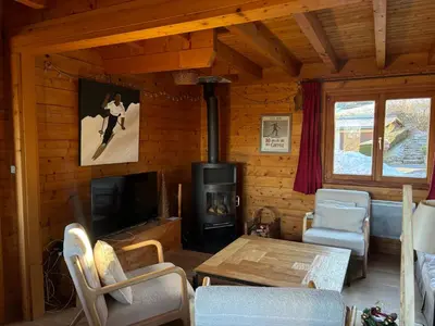 a living room with a fireplace and a stove at Chalet de charme aux Carroz d'Arrâches-Flaines in Les Carroz d'Araches