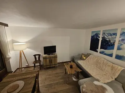 a living room with a couch and a tv at Appartement Cosy, Vue Mont Blanc, Plein Centre in Chamonix-Mont-Blanc