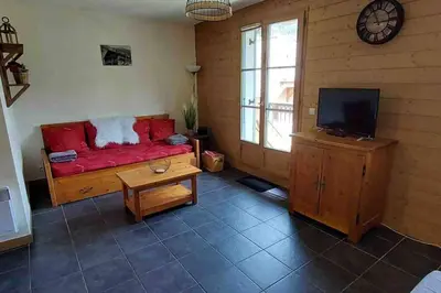 a living room with a red couch and a tv at Charmant appartement T3 avec magnifique vue in Saint-Gervais-les-Bains